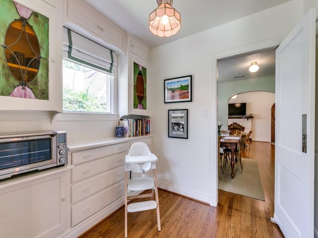 819 Clermont Ave, Dallas, TX 75223 - sitting room featuring arched walkways, light wood finished floors, and baseboards