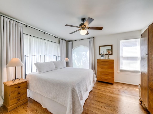 819 Clermont Ave, Dallas, TX 75223 - bedroom with light wood-type flooring, baseboards, and ceiling fan