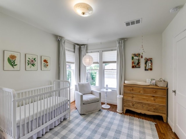 819 Clermont Ave, Dallas, TX 75223 - bedroom with wood finished floors and a nursery area
