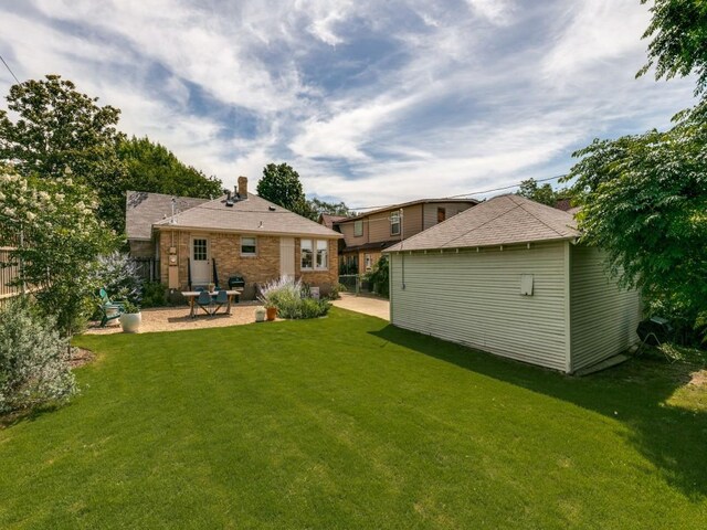 819 Clermont Ave, Dallas, TX 75223 - rear view of property featuring a patio, a yard, an outdoor structure, and brick siding
