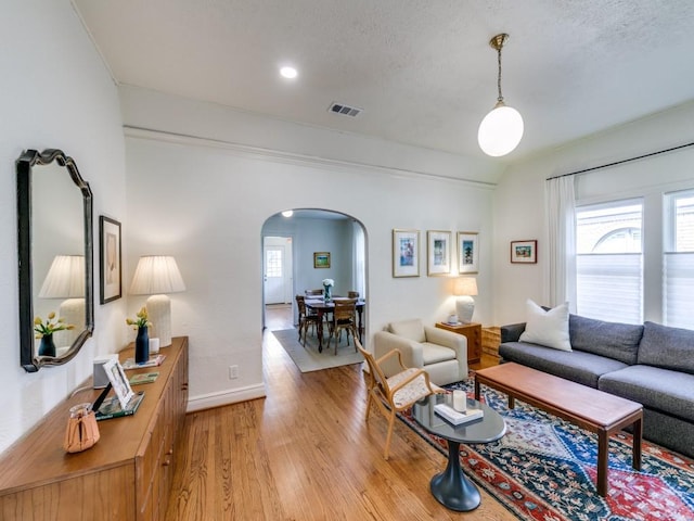 819 Clermont Ave, Dallas, TX 75223 - living area featuring arched walkways, light wood-type flooring, and baseboards