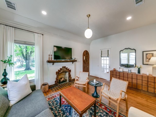 819 Clermont Ave, Dallas, TX 75223 - living room with wood finished floors, arched walkways, and a fireplace
