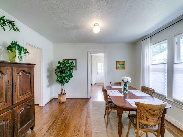 819 Clermont Ave, Dallas, TX 75223 - dining space featuring plenty of natural light, a textured ceiling, light wood finished floors, crown molding, and baseboards
