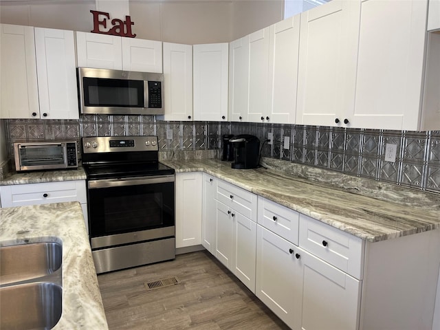 120 County Road 1719, Clifton, TX 76634 - kitchen featuring appliances with stainless steel finishes, backsplash, and white cabinetry