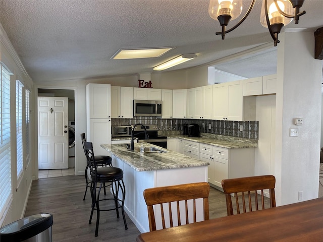 120 County Road 1719, Clifton, TX 76634 - kitchen featuring appliances with stainless steel finishes, vaulted ceiling, backsplash, white cabinets, and a textured ceiling