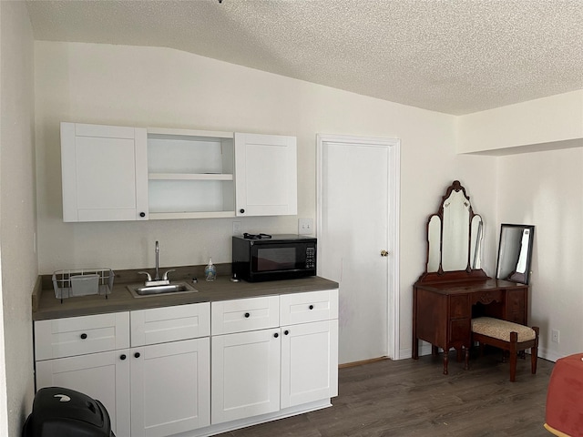 120 County Road 1719, Clifton, TX 76634 - kitchen featuring a sink, black microwave, dark wood-type flooring, dark countertops, and white cabinetry