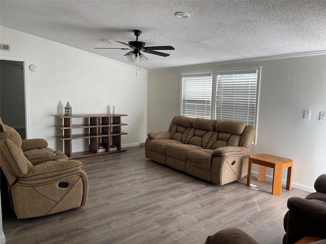 120 County Road 1719, Clifton, TX 76634 - living room with ornamental molding, a textured ceiling, a ceiling fan, wood finished floors, and baseboards