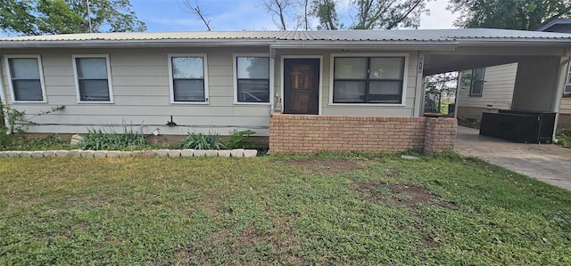 911 Calcutta St, Brady, TX 76825 - view of front of home featuring an attached carport, metal roof, a front yard, and driveway