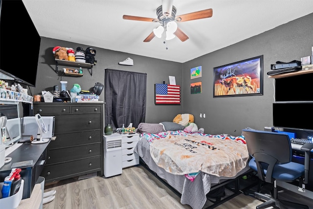 105 S Lavaca St, Whitney, TX 76692 - bedroom with light wood-type flooring, a textured wall, a desk, and ceiling fan