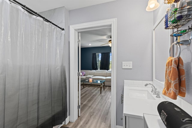 105 S Lavaca St, Whitney, TX 76692 - full bath with vanity, wood finished floors, a ceiling fan, and a shower with shower curtain
