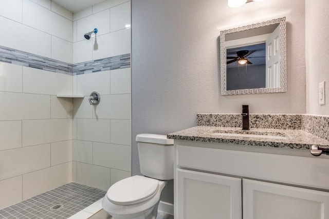 616 Hiland St, Garland, TX 75040 - bathroom with vanity, toilet, a tile shower, ceiling fan, and a textured wall