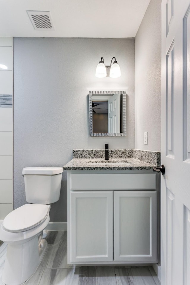 616 Hiland St, Garland, TX 75040 - bathroom featuring toilet, vanity, and baseboards