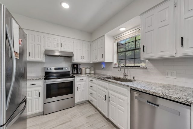 7020 Live Oak Dr, North Richland Hills, TX 76182 - kitchen with stainless steel appliances, a sink, under cabinet range hood, white cabinets, and recessed lighting