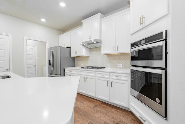 1519 Fairweather Way, Forney, TX 75126 - kitchen featuring stainless steel appliances, under cabinet range hood, recessed lighting, decorative backsplash, and light countertops