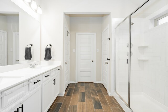 1519 Fairweather Way, Forney, TX 75126 - full bathroom with double vanity, a stall shower, wood finished floors, and baseboards
