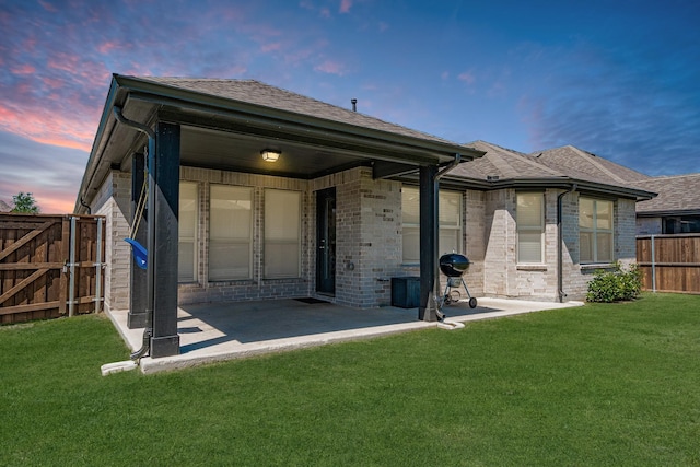 1519 Fairweather Way, Forney, TX 75126 - back of house at dusk with a patio area, a shingled roof, brick siding, and a gate