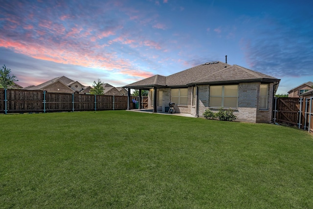 1519 Fairweather Way, Forney, TX 75126 - back of house at dusk with brick siding, a patio area, and roof with shingles