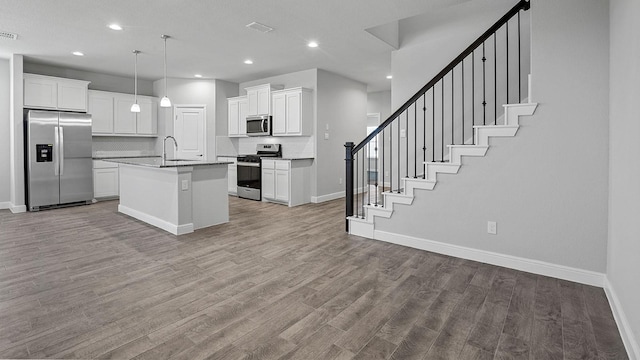 105 Leon Ave, Rhome, TX 76078 - kitchen with appliances with stainless steel finishes, baseboards, a sink, open floor plan, and decorative backsplash