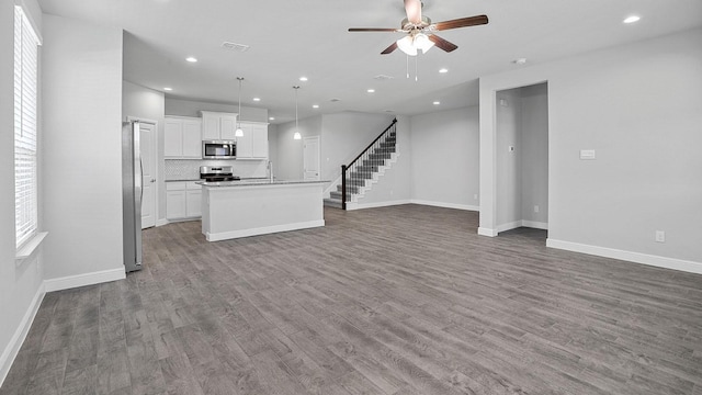 105 Leon Ave, Rhome, TX 76078 - unfurnished living room featuring a sink, a ceiling fan, baseboards, wood finished floors, and recessed lighting