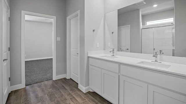 105 Leon Ave, Rhome, TX 76078 - full bathroom featuring double vanity, wood finished floors, a stall shower, and baseboards
