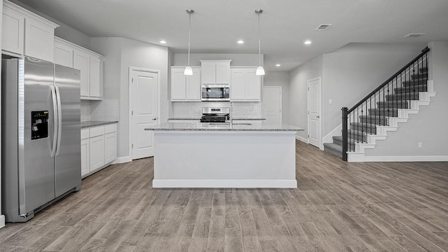 105 Leon Ave, Rhome, TX 76078 - kitchen with stainless steel appliances, baseboards, backsplash, wood finished floors, and recessed lighting