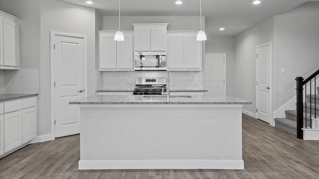 105 Leon Ave, Rhome, TX 76078 - kitchen with stainless steel appliances, recessed lighting, an island with sink, white cabinets, and backsplash