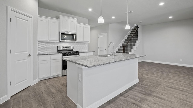 105 Leon Ave, Rhome, TX 76078 - kitchen with appliances with stainless steel finishes, a sink, wood finished floors, baseboards, and white cabinets