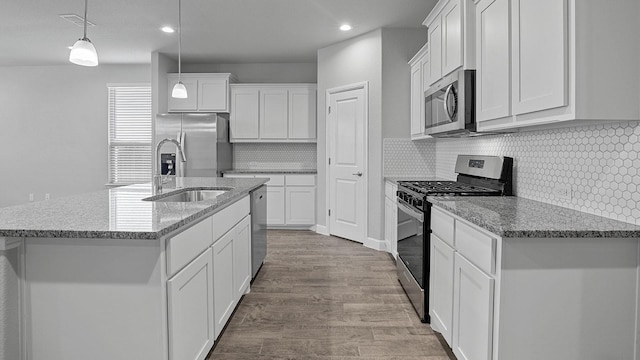 105 Leon Ave, Rhome, TX 76078 - kitchen with appliances with stainless steel finishes, a sink, wood finished floors, white cabinetry, and recessed lighting