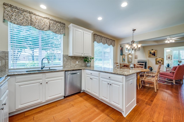 382 Burnswick Isles Way, Frisco, TX 75036 - kitchen with stainless steel dishwasher, a sink, a chandelier, light wood finished floors, and a peninsula