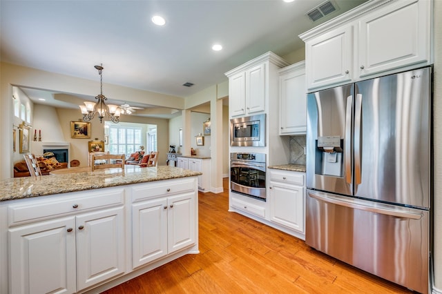 382 Burnswick Isles Way, Frisco, TX 75036 - kitchen with appliances with stainless steel finishes, a chandelier, white cabinetry, light wood finished floors, and recessed lighting