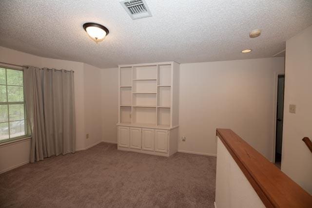 1111 Bayshore St, Allen, TX 75002 - empty room featuring a textured ceiling, light carpet, and baseboards