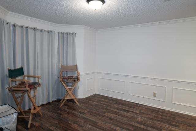 1111 Bayshore St, Allen, TX 75002 - empty room with dark wood-style floors, a textured ceiling, crown molding, a wainscoted wall, and a decorative wall