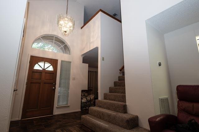1111 Bayshore St, Allen, TX 75002 - entryway featuring stairs, a chandelier, a high ceiling, and dark stone finish floors