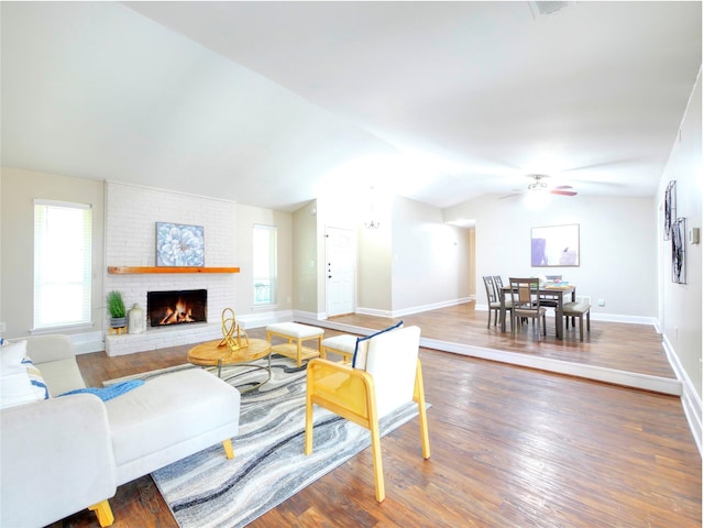 3609 Marwick Dr, Plano, TX 75075 - living area with vaulted ceiling, a ceiling fan, a brick fireplace, wood finished floors, and baseboards