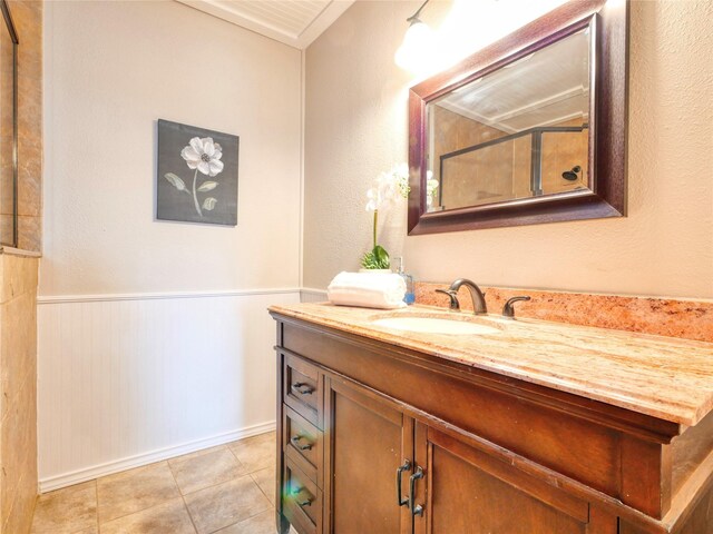 3609 Marwick Dr, Plano, TX 75075 - bathroom featuring vanity, a wainscoted wall, tile patterned flooring, crown molding, and baseboards