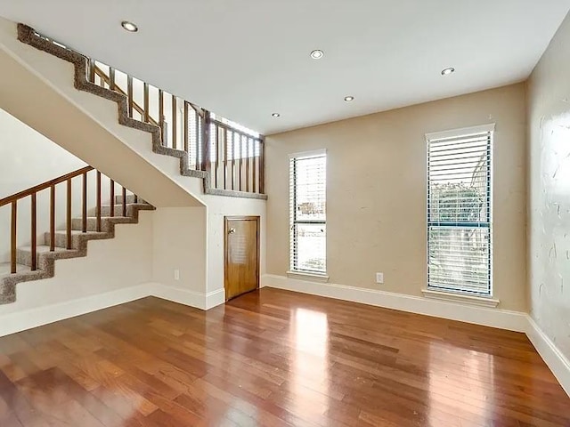 1101 Shawnee Trl, Carrollton, TX 75007 - unfurnished living room featuring wood finished floors, stairway, baseboards, and recessed lighting