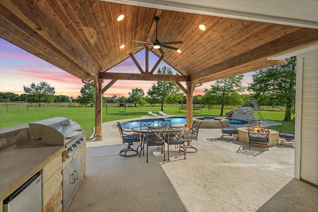9390 Lakeridge Dr, Princeton, TX 75407 - patio terrace at dusk with an outdoor fire pit, a gazebo, a lawn, ceiling fan, and a patio area