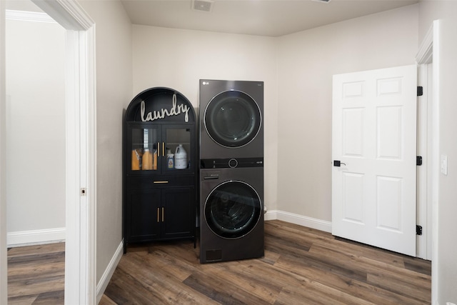 9390 Lakeridge Dr, Princeton, TX 75407 - washroom with stacked washer / dryer, cabinet space, and dark wood-style floors