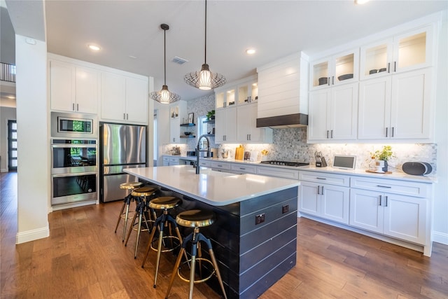 2402 Cornerstone Dr, Mansfield, TX 76063 - kitchen with stainless steel appliances, a center island with sink, light countertops, decorative backsplash, and dark wood-style floors