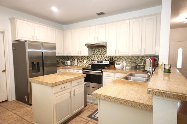 3231 Torio, Grand Prairie, TX 75054 - kitchen featuring appliances with stainless steel finishes, under cabinet range hood, a peninsula, a sink, and decorative backsplash