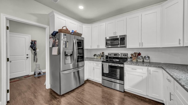 113 Myers Ave, Cleburne, TX 76033 - kitchen featuring appliances with stainless steel finishes, dark wood finished floors, white cabinetry, light stone countertops, and backsplash