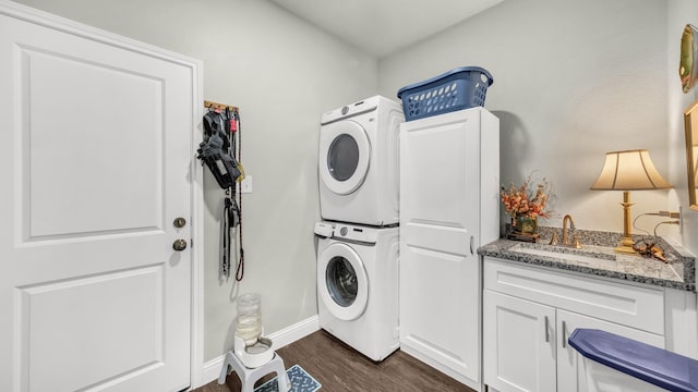 113 Myers Ave, Cleburne, TX 76033 - laundry area featuring stacked washer and clothes dryer, dark wood-style flooring, baseboards, and cabinet space
