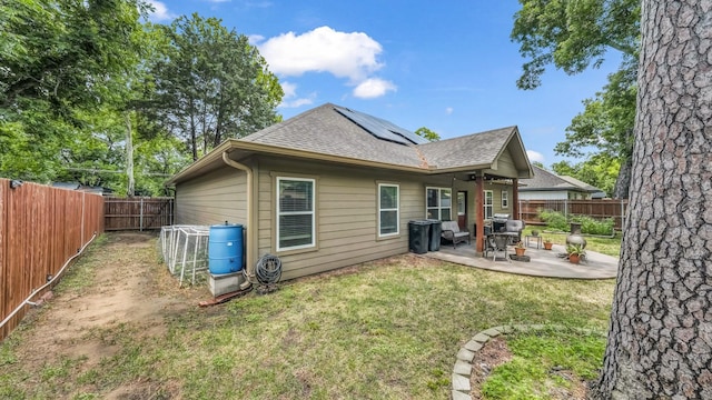 113 Myers Ave, Cleburne, TX 76033 - back of property with roof with shingles, roof mounted solar panels, and a patio