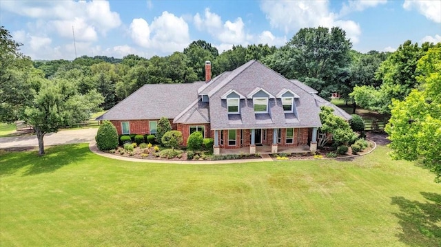 15741 Big Horn Trl, Frisco, TX 75035 - view of front facade with brick siding, covered porch, a front yard, and a chimney