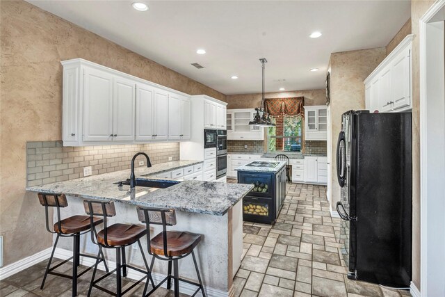 15741 Big Horn Trl, Frisco, TX 75035 - kitchen featuring appliances with stainless steel finishes, a sink, a peninsula, white cabinets, and backsplash