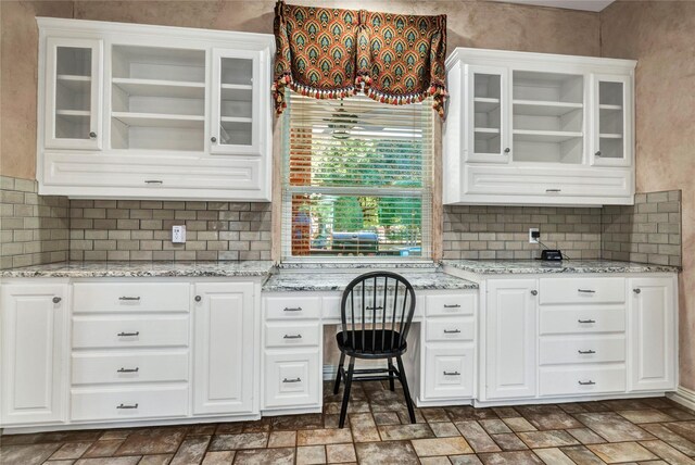 15741 Big Horn Trl, Frisco, TX 75035 - kitchen featuring white cabinetry, decorative backsplash, open shelves, glass insert cabinets, and light stone counters