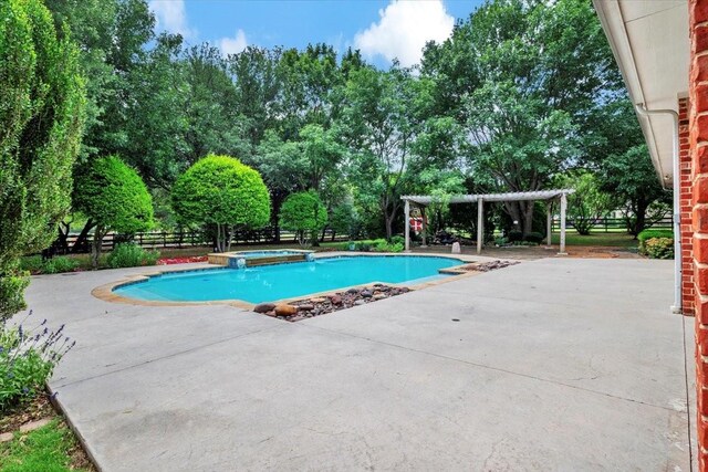 15741 Big Horn Trl, Frisco, TX 75035 - view of pool featuring a patio, a pool with connected hot tub, a pergola, and view of wooded area