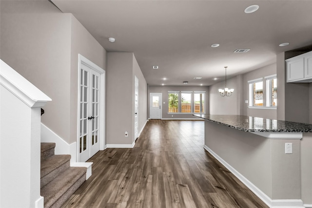 106 Camelia St, Garland, TX 75043 - unfurnished living room featuring dark wood-type flooring, a chandelier, recessed lighting, baseboards, and stairway