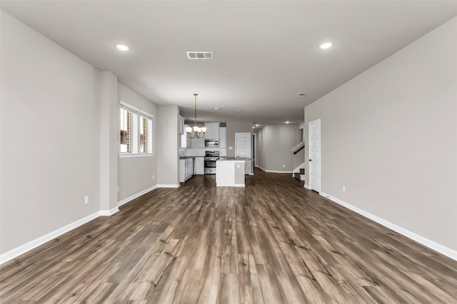 106 Camelia St, Garland, TX 75043 - unfurnished living room with a chandelier, dark wood finished floors, baseboards, recessed lighting, and stairway