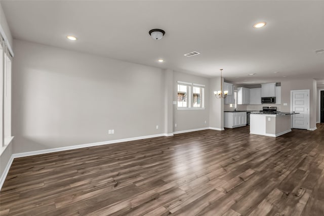 106 Camelia St, Garland, TX 75043 - unfurnished living room with a chandelier, baseboards, dark wood-style floors, and recessed lighting
